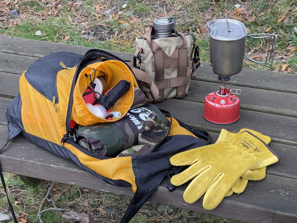 Bushcraft gear - leather gloves, titanium canteen with nesting mug - using a mini gas stove 